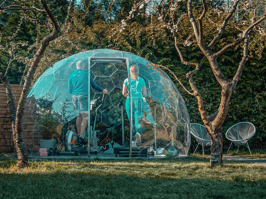 Ein Paar trainiert in einem Garten-Iglu-Fitnessstudio