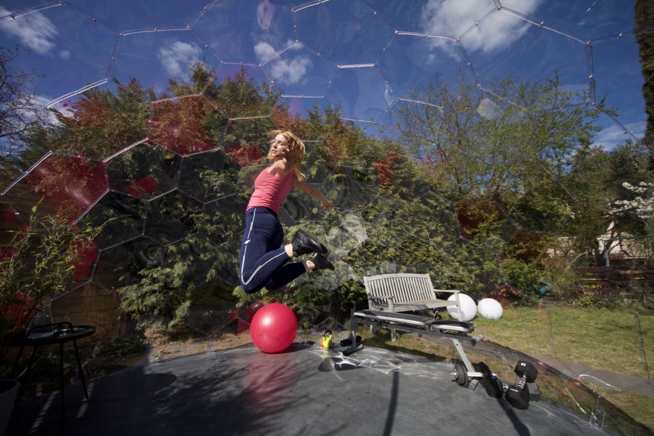 Une femme saute lors d'une séance d'entraînement dans une salle de sport de jardin.