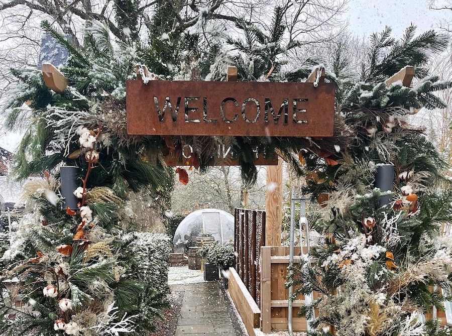 Außenbereich mit Winterdekoration und einer riesigen Schneekugel