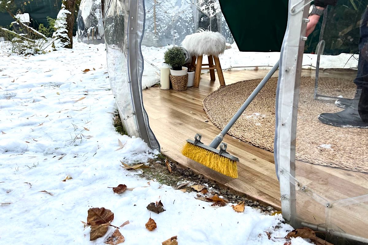 Spazzare via le foglie dalla cupola del giardino per l'inverno