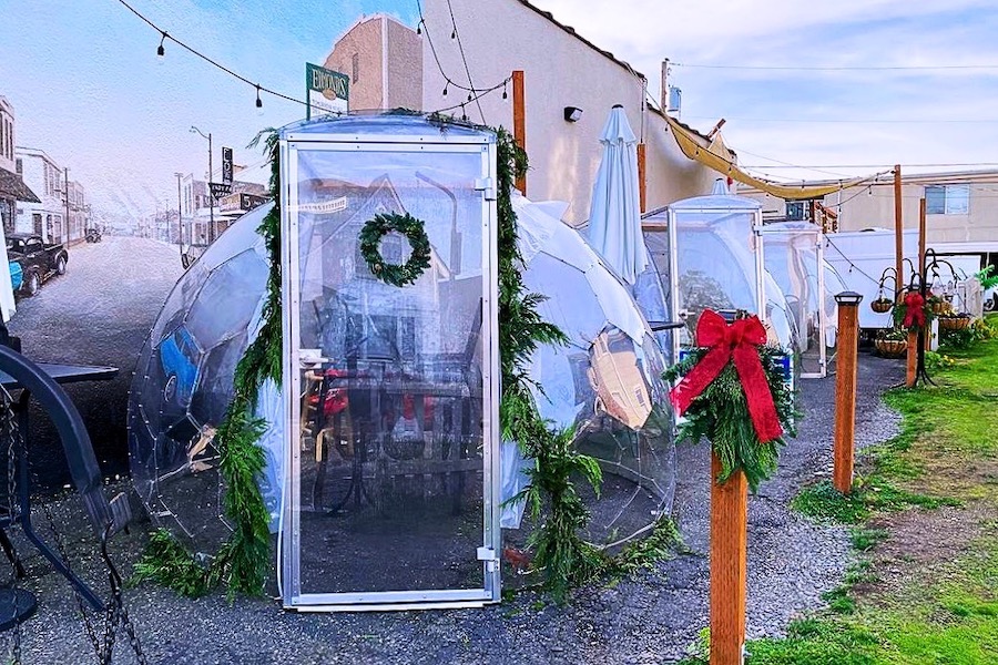 Baccelli da pranzo decorati con spirito natalizio, con ghirlande, rami d'albero, nastri rossi e campanelle