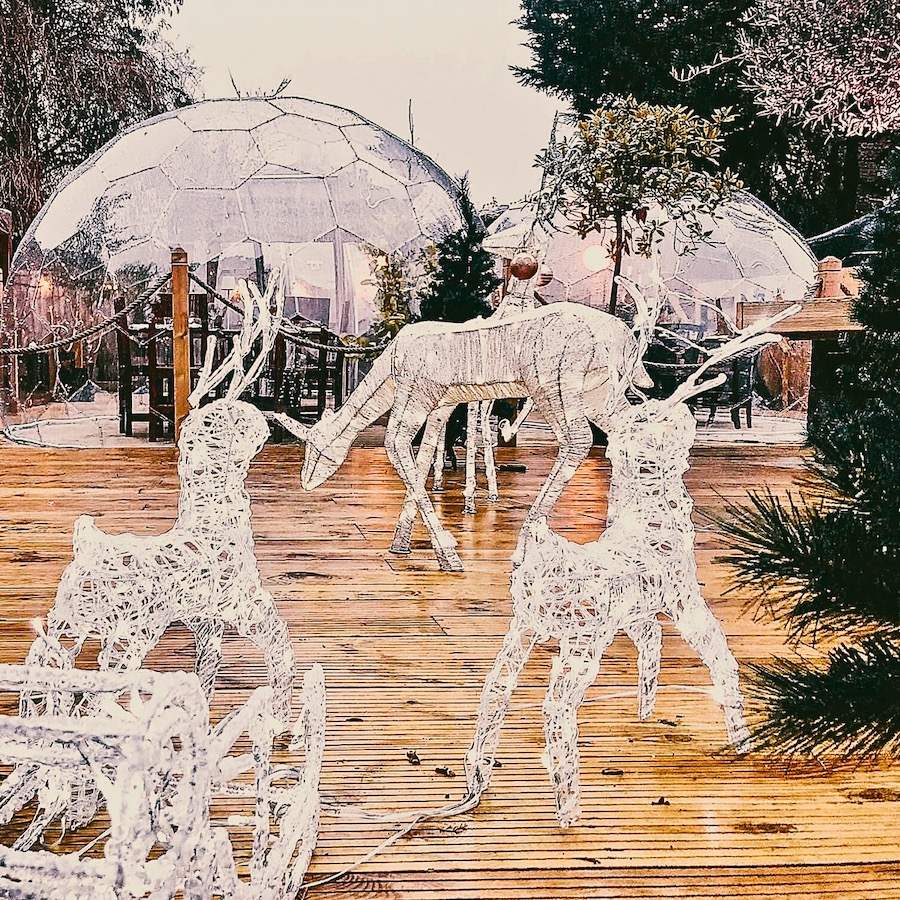 Spazio all'aperto di un ristorante, con cupola e decorazioni luminose di renne