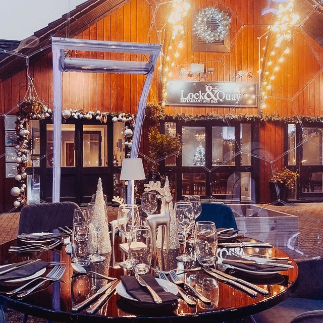 Un tavolo all'interno di una cupola da pranzo, con ornamenti e luci natalizie.