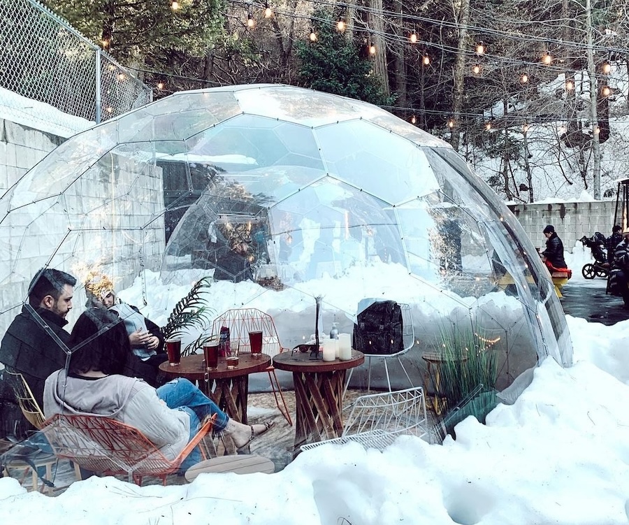 Un interno accogliente e caldo di una cupola invernale negli spazi esterni innevati di un bar di montagna