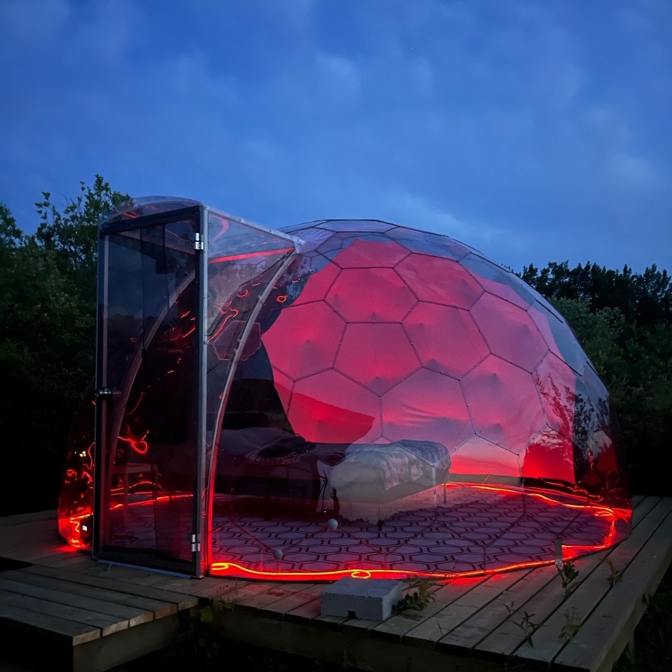 Glamping-Kuppel bei Nacht, mit roter Beleuchtung