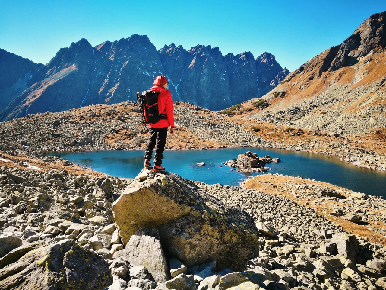Un uomo in piedi sulla roccia, che osserva il lago