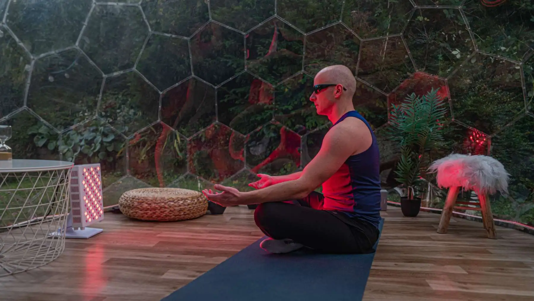 Man exercising in a Hypedome wellness space with red light for a backyard wellness retreat centred on longevity