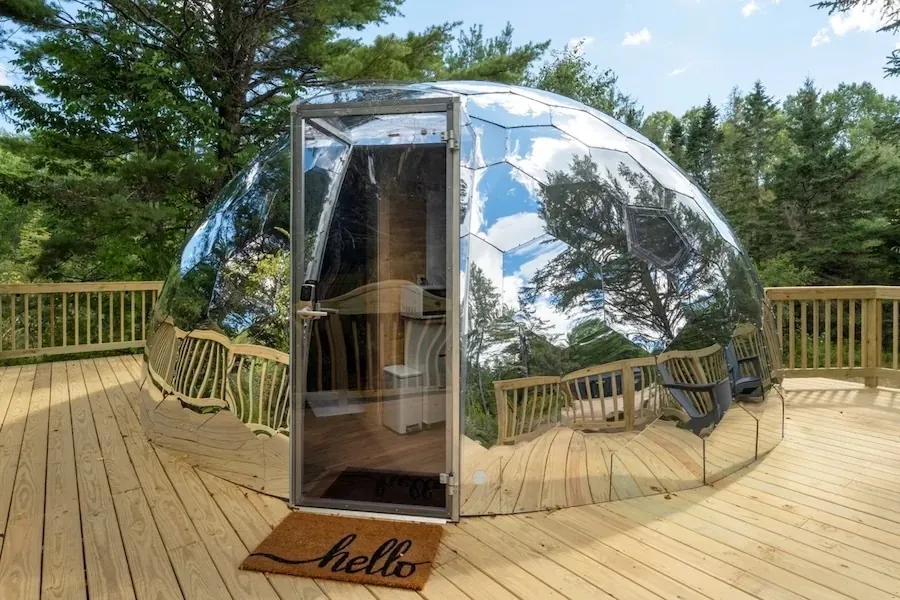 Interior of a glamping dome suite with bedroom and view