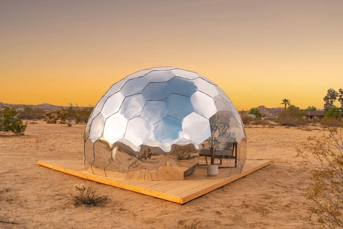 A mirrored Hypedome on a wooden deck in the desert at sunset