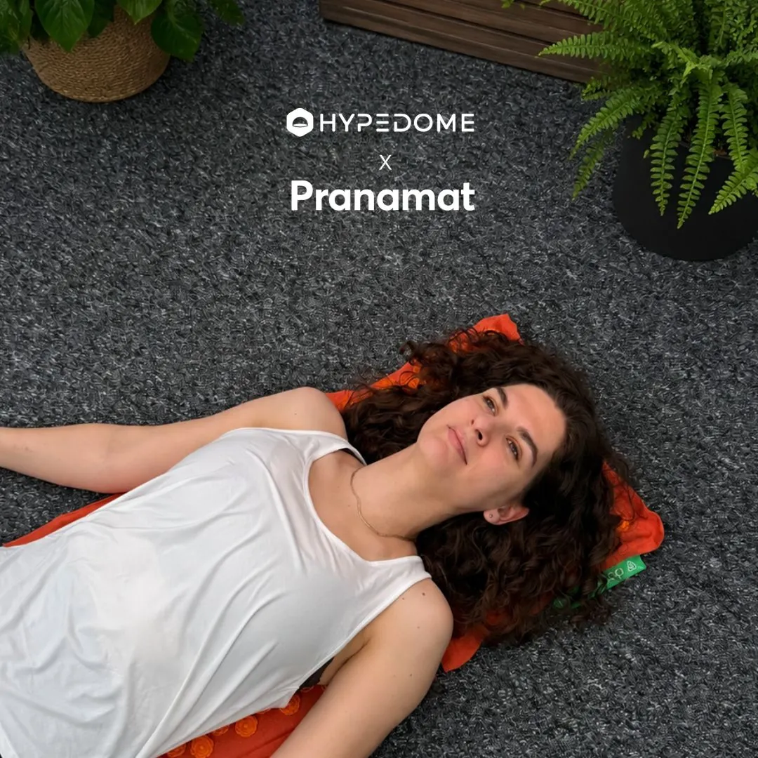 A person resting on an orange Pranamat acupressure mat — Hypedome x Pranamat