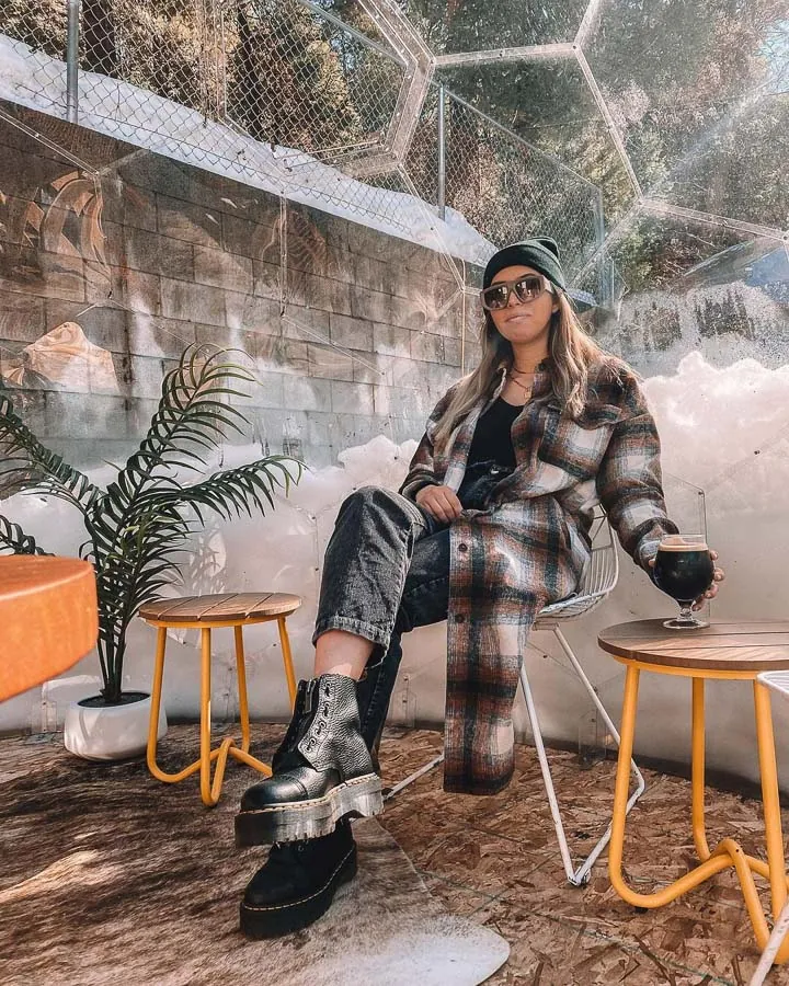 Woman drinking mulled wine in a dining pod in the winter